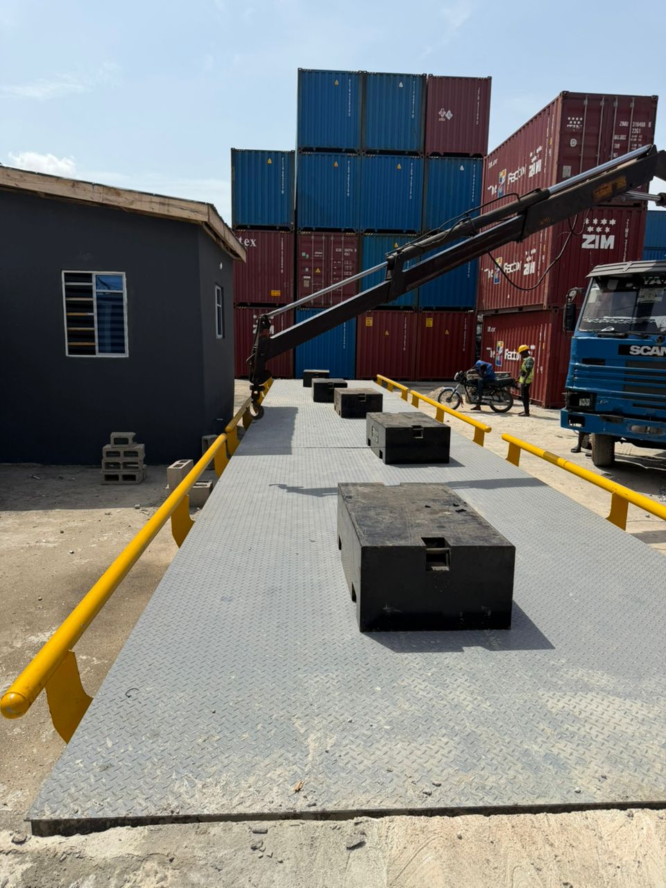 Crane lowering calibration test weights onto a Kira Scales weighbridge at Apapa port