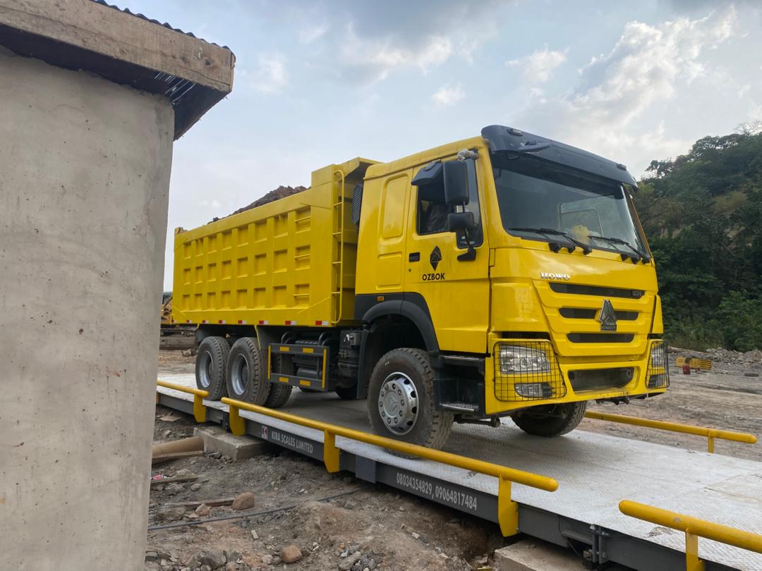 Yellow HOWO dump truck weighing on a newly installed Kira Scales weighbridge